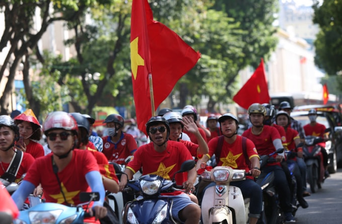 Cờ tổ quốc tung bay trong tiết trời thu Hà Nội, trên mặt nhiều cổ động viên tỏ rõ sự háo hức, đón chờ trận đấu.