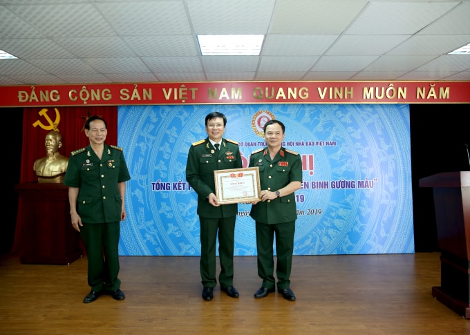 Trung tướng Khuất Việt Dũng, Phó Chủ tịch Hội Cựu chiến binh Việt Nam trao tặng Kỷ niệm chương Cựu chiến binh Việt Nam cho đồng chí Hồ Quang Lợi, Phó Bí thư Đảng đoàn, Bí thư Đảng ủy, Phó Chủ tịch Thường trực Cơ quan Trung ương Hội Nhà báo Việt Nam vì đã có thành tích góp phần xây dựng và hoạt động của Hội Cựu chiến binh. Ảnh: Sơn Hải