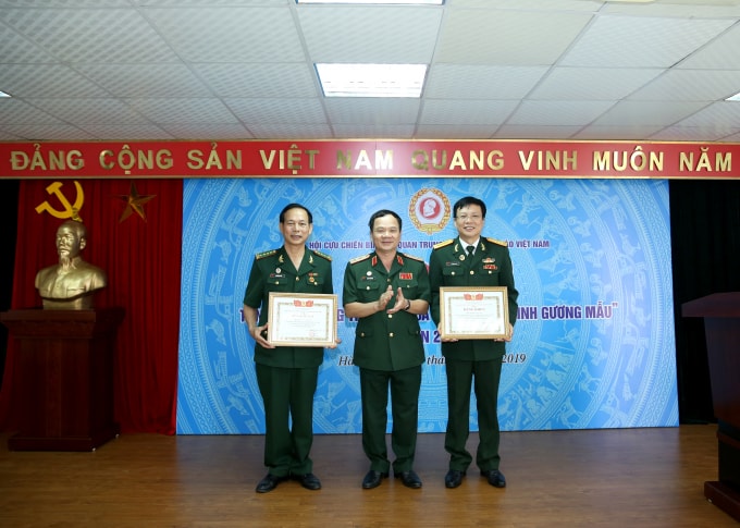 Trung tướng Khuất Việt Dũng, Phó Chủ tịch Hội Cựu chiến binh Việt Nam tặng bằng khen cho đồng chí Hồ Quang Lợi - Phó Chủ tịch Thường trực Hội Nhà báo Việt Nam và đồng chí Nguyễn Hòa Văn - Giám đốc Cổng Thông tin Điện tử, Chủ tịch Hội Cựu chiến binh Cơ quan TƯ Hội Nhà báo Việt Nam. Ảnh: Sơn Hải