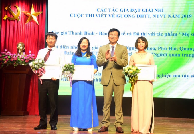 Phó Chủ tịch Thường trực Hội Nhà báo Việt Nam Hồ Quang Lợi trao giải Nhì cho các tác giả. Ảnh: Hiền Thu