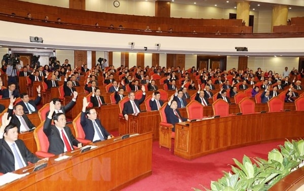 Các đồng chí lãnh đạo Đảng, Nhà nước và các đại biểu biểu quyết thông qua Nghị quyết Hội nghị Trung ương lần thứ 11. Ảnh: TTXVN