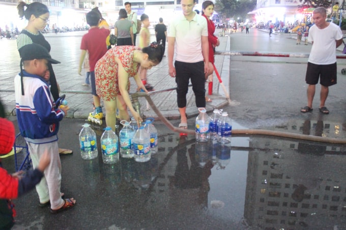 Người dân khu đô thị Linh Đàm quận Hoàng Mai khốn khổ đi lấy nước sạch. Ảnh Minh Nguyệt.