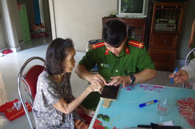 Cán bộ công an Thừa Thiên - Huế đến nhà hỗ trợ người dân cao tuổi làm thủ tục cấp, đổi giấy Chứng minh nhân dân.