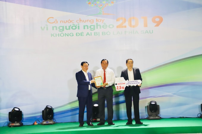 Thành viên HĐTV, Tổng Giám đốc Agribank Tiết Văn Thành (giữa) trao ủng hộ 2,5 tỷ đồng cho hoạt động an sinh xã hội và Quỹ Vì người nghèo và nhận kỷ niệm chương từ Phó Thủ tướng Vương Đình Huệ cho doanh nghiệp có nhiều đóng góp đối với Chương trình.