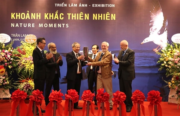 NSNA Trần Lam nhận cup của các tổ chức nhiếp ảnh quốc tế tại lễ khai mạc triển lãm. Ảnh: laodong.vn