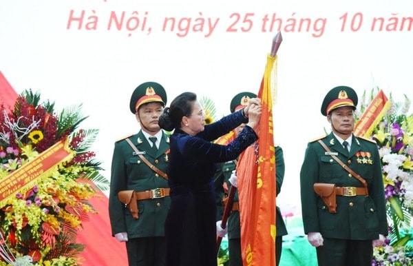 Chủ tịch Quốc hội Nguyễn Thị Kim Ngân gắn Huy hiệu Anh hùng lực lượng vũ trang nhân dân lên Quân kỳ Quyết thắng của Tổng cục II