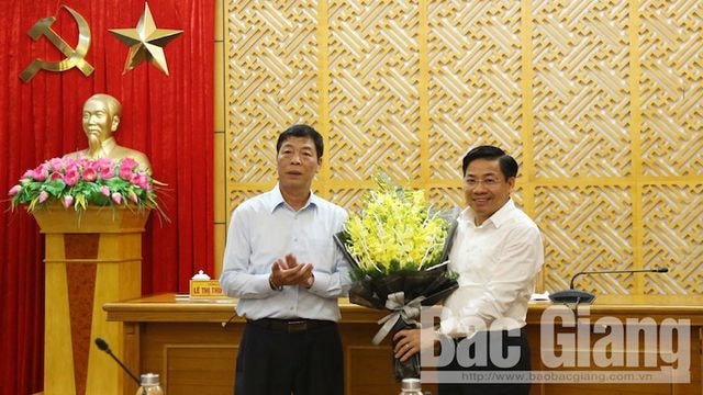 Bí thư Tỉnh uỷ Bắc Giang Bùi Văn Hải tặng hoa chúc mừng tân Phó Bí thư tỉnh uỷ Bắc Giang Dương Văn Thái (ảnh trái). Ảnh: Báo Bắc Giang