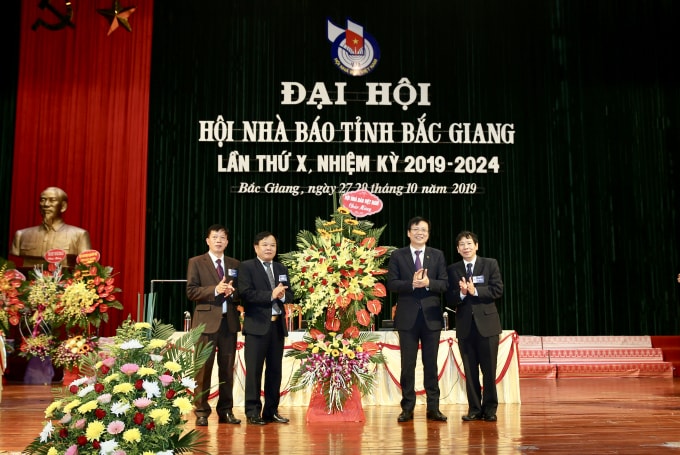 Đồng chí Hồ Quang Lợi, Phó Chủ tịch Thường trực Hội Nhà báo Việt Nam tặng hoa chúc mừng Hội Nhà báo tỉnh Bắc Giang. Ảnh: Sơn Hải