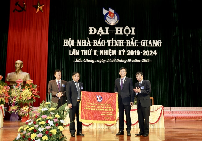 Đồng chí Hồ Quang Lợi, Phó Chủ tịch Thường trực Hội Nhà báo Việt Nam trao bức trướng cho Hội Nhà báo tỉnh Bắc Giang. Ảnh: Sơn Hải
