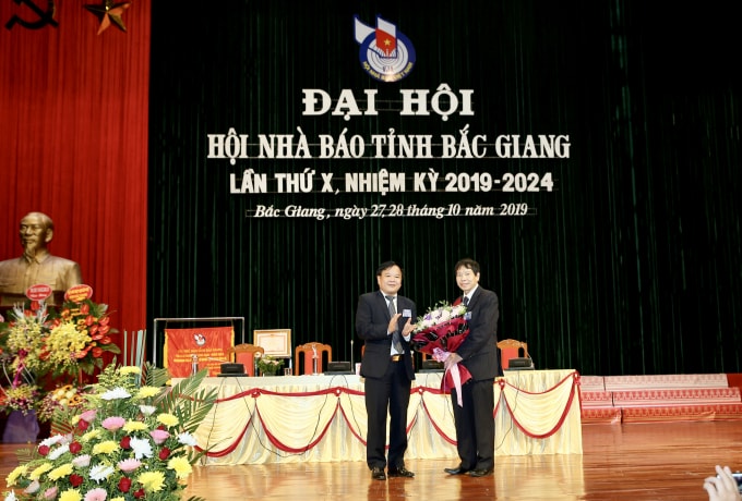 Đồng chí Trịnh Văn Ánh, Chủ tịch Hội Nhà báo tỉnh Bắc Giang khóa X nhiệm kỳ 2014-2019 tặng hoa đồng chí Nguyễn Thế Dũng, nguyên Chủ tịch Hội Nhà báo tỉnh Bắc Giang. Ảnh: Sơn Hải