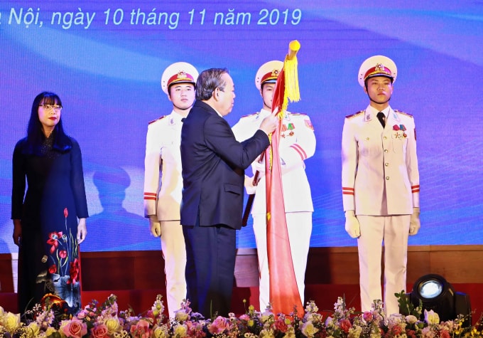 Phó Thủ tướng Thường trực Trương Hòa Bình gắn Huân chương Lao động hạng Nhất lên lá cờ truyền thống của trường. - Ảnh: VGP