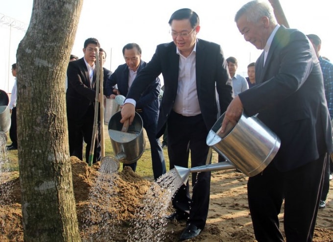Phó Thủ tướng Vương Đình Huệ, Giám mục Nguyễn Hữu Long cùng các đại biểu trồng cây đại đoàn kết trong khuôn viên Nhà Văn xóm Tân Lập 1. Ảnh: VGP