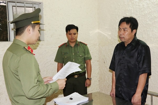 Tống đạt quyết định khởi tố bị can đối với Nguyễn Minh Cầm. Ảnh CAHT