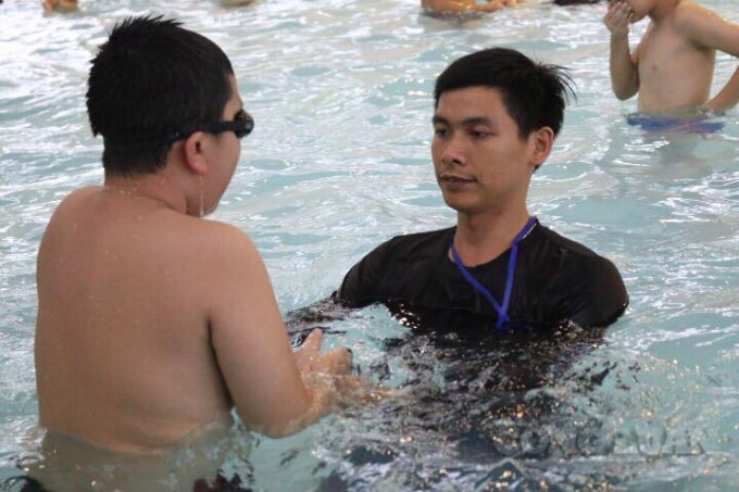 Thầy Chinh đang hướng dẫn cách lấy hơi cho học sinh tại bể bơi Đền Lừ.