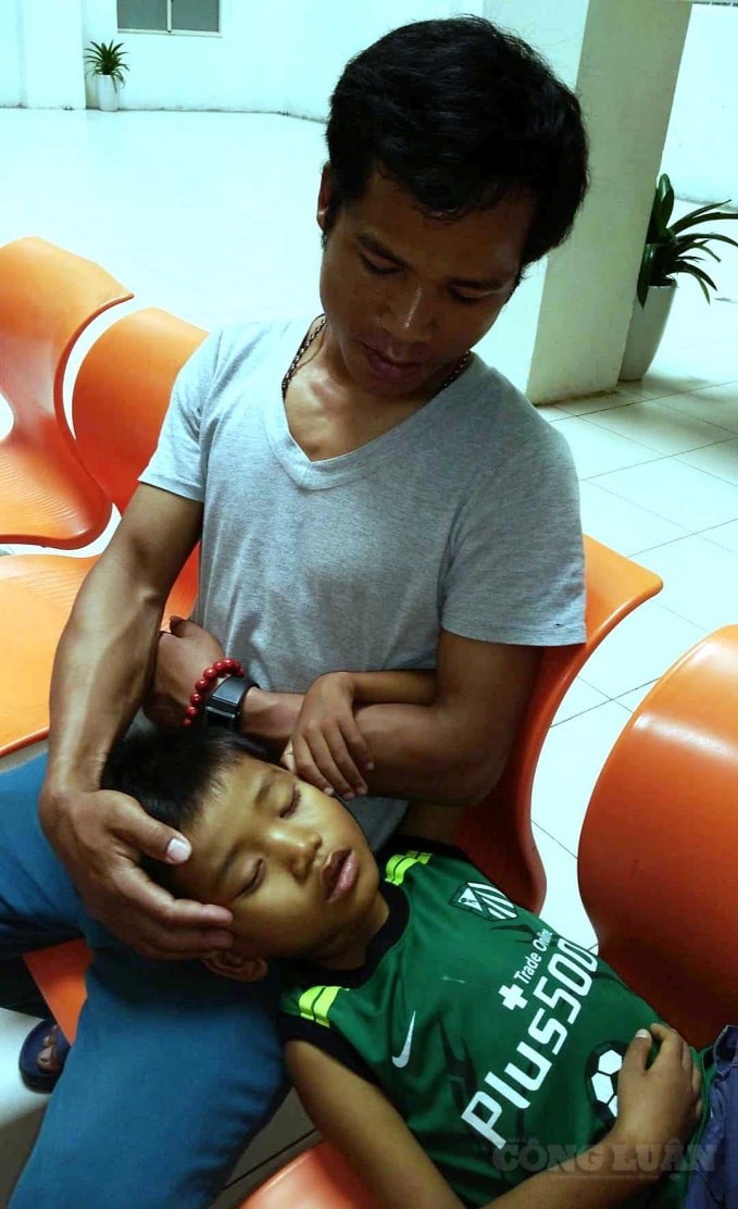 Hai cha con ôm nhau khóc ngoài hành lang của bệnh viện (Ảnh: Cái Văn Long).