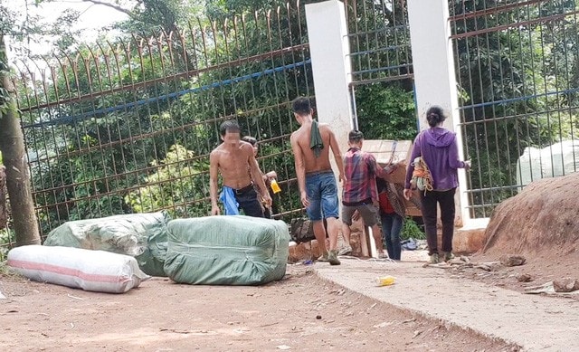Nhiều bao hàng lớn bị mắc kẹt qua cánh cửa hàng rào biên giới, phải rất khó khăn nhóm cửu vạn mới đưa qua được.
