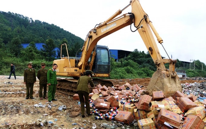 Lực lượng chức năng giám sát việc tiêu hủy nước mắm giả, không có giá trị sử dụng. Ảnh báonghệan