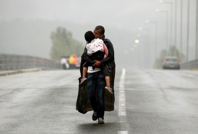 Một người di cư hôn con gái mình khi đi bộ tới biên giới giữa Hy Lạp và Macedonia,10/09/2015. Ảnh: Reuters
