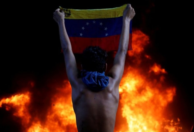 Một người biểu tình cầm cờ Venezuela bên ngoài tòa án tối cao ở thủ đô Caracas, 12/06/2017. Ảnh: Reuters