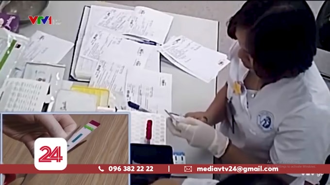 Kỹ thuật viên cắt đôi que thử xét nghiệm HIV/ Viêm gan B (Ảnh chụp màn hình)