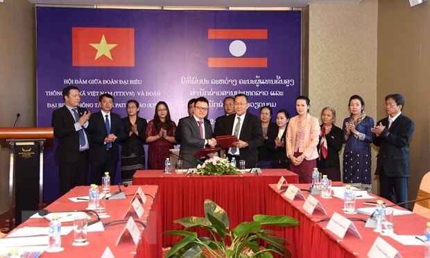 Tổng giám đốc Thông tấn xã Pathet Lào Sounthone Khathavong và Phó Tổng Giám đốc Thông tấn xã Việt Nam Lê Quốc Minh ký kết biên bản hợp tác sau hội đàm. Ảnh: Phạm Kiên/TTXVN