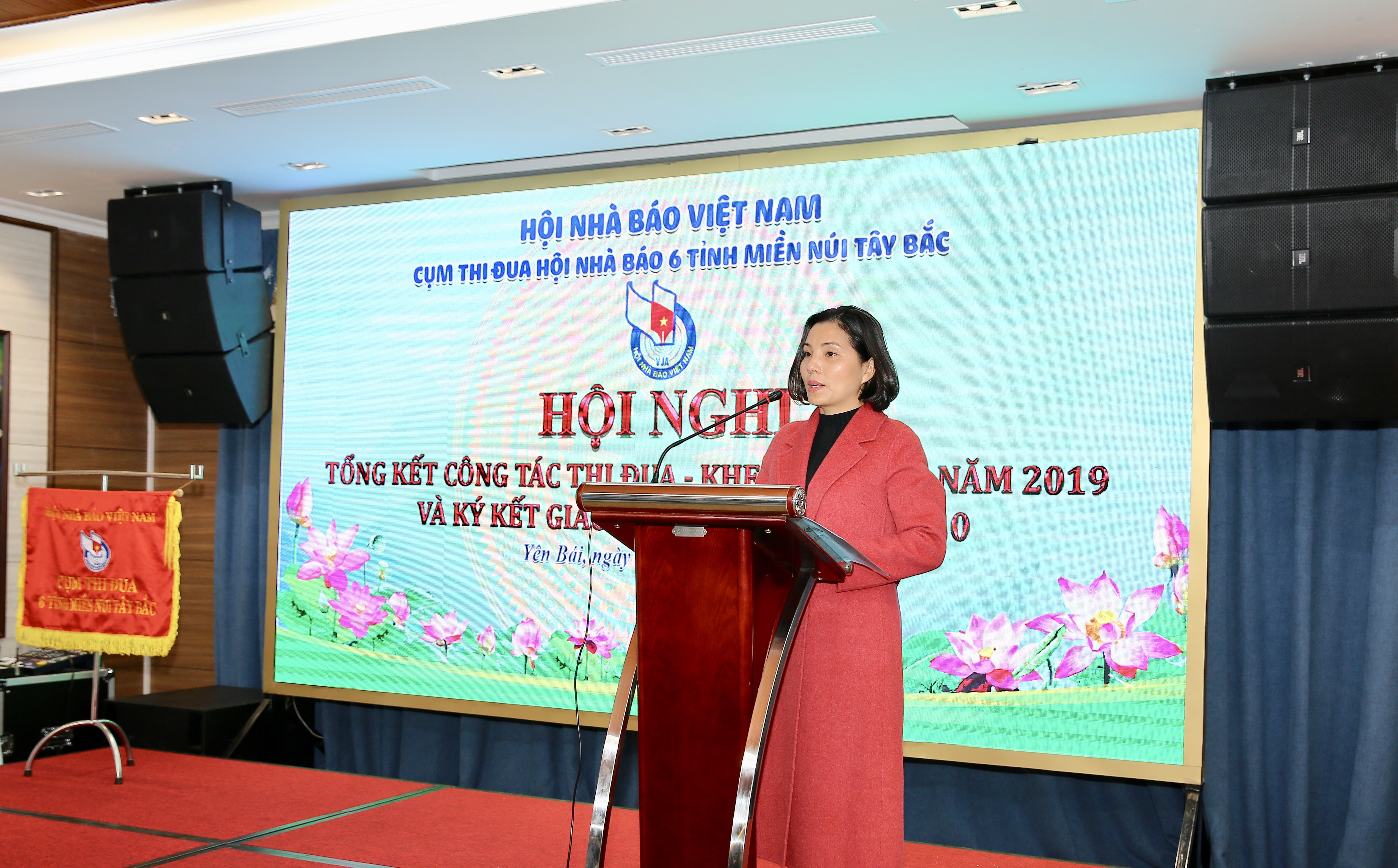 Đồng chí Nguyễn Thị Thanh Thùy, Phó Chánh Văn phòng Hội Nhà báo tỉnh Yên Bái đã đọc báo cáo tổng kết công tác thi đua - khen thưởng năm 2019 của Cụm thi đua Hội Nhà báo các tỉnh miền núi Tây Bắc. Ảnh: Sơn Hải
