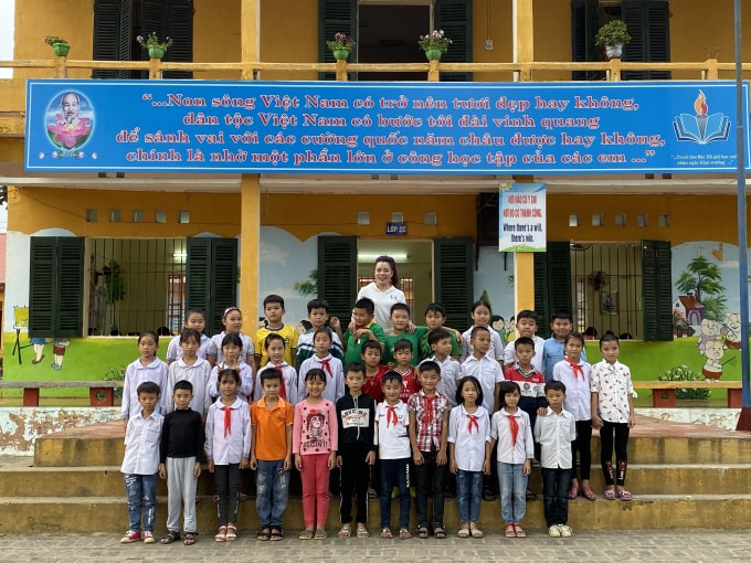 Tiến Anh cùng cô giáo chủ nhiệm và các bạn đồng trang lứa. Ảnh: Thủy Tiên