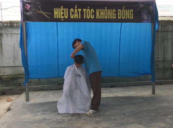Thầy giáo đang chăm chú, tỉ mẩn hớt từng sợi tóc cho những cậu học trò của mình