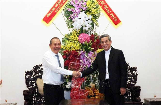 Ủy viên Bộ Chính trị, Phó Thủ tướng Thường trực Chính phủ Trương Hòa Bình, trao lẵng hoa của Tổng Bí thư, Chủ tịch Nước Nguyễn Phú Trọng chúc mừng Tổng Giám mục Nguyễn Năng, Tổng Giám mục Giáo phận Thành phố Hồ Chí Minh nhân dịp lễ Giáng sinh 2019. Ảnh: TTXVN