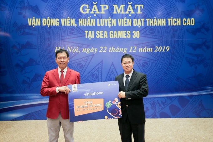 Ông Nguyễn Trường Giang - Phó TGĐ VinaPhone (bên phải) trao quà tặng cho đại diện Đoàn thể thao - ông Trần Đức Phấn, Phó Tổng cục trưởng TC TDTT.