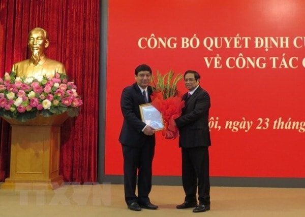 Ông Phạm Minh Chính, Ủy viên Bộ Chính trị, Bí thư Trung ương Đảng, Trưởng Ban Tổ chức Trung ương trao quyết định của Bộ Chính trị và tặng hoa chúc mừng ông Nguyễn Đắc Vinh. Ảnh: TTXVN
