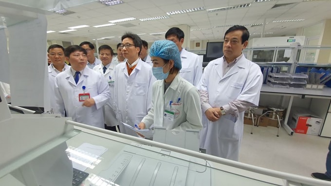 Phó Thủ tướng Vũ Đức Đam (thứ 3 từ phải) kiểm tra phương tiện xét nghiệm tại Bệnh viện Bệnh nhiệt đới Trung ương. Ảnh Bộ Y tế.
