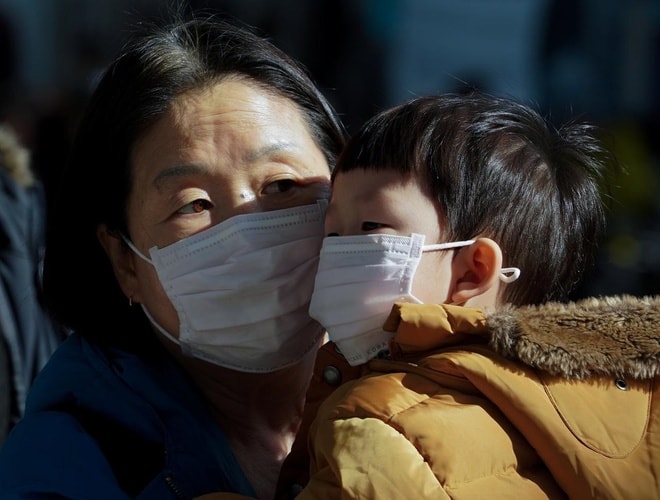 Một người mẹ và đứa con đeo khẩu trang để tránh tiếp xúc với loại virus corona mới ở Seoul, Hàn Quốc, ngày 26/1. Ảnh: Yonhap/Reuters.