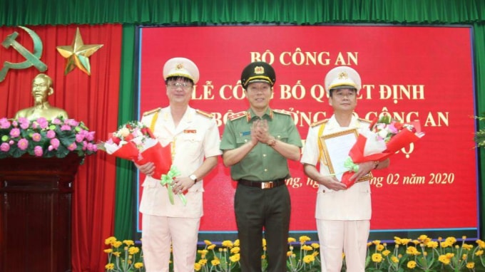 Trung tướng Lương Tam Quang trao Quyết định và tặng hoa chúc mừng Đại tá Nguyễn Minh Ngọc (phải) và Đại tá Lê Minh Quang.