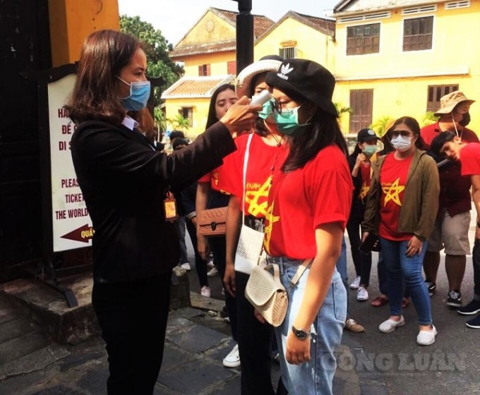 Đo thân nhiệt cho du khách tham quan phố cổ.