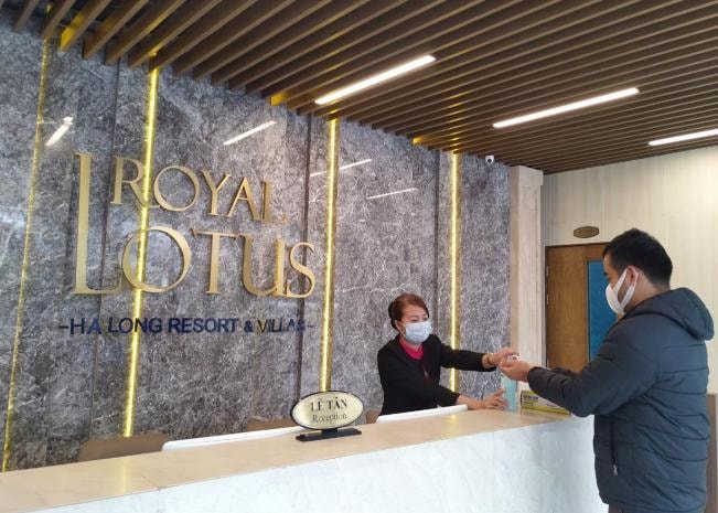 Nhân viên lễ tân của Royal Lotus Halong Resort & Villas hướng dẫn du khách vệ sinh, khử trùng tay. ẢNh do BIM Group cung cấp.