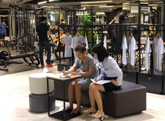 Nhân viên Elite Fitness hướng dẫn khách hàng thực hiện khảo sát về thông tin di chuyển trong thời gian dịch bùng phát. Ảnh do BIM Group cung cấp.