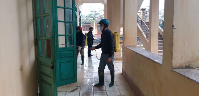 Cơ quan chức năng huyện Chiêm Hóa (Tuyên Quang) phun khử trùng bàn ghế, sàn nhà, các cánh cửa, lan can hành lang tại trường THPT Hà Lang. Ảnh Đoàn Cường.