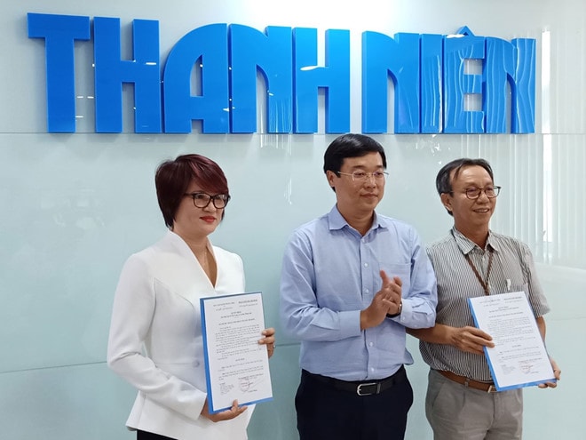 Anh Lê Quốc Phong (giữa) trao quyết định sáp nhập Tạp chí Thời Trang Trẻ vào Báo Thanh Niên. Ảnh: Vương Quan Khải