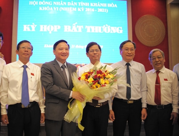 Ông Nguyễn Tấn Tuân (người đứng giữa) nhận hoa chúc mừng từ Bí thư Tỉnh ủy Khánh Hòa Nguyễn Khắc Định. Ảnh: vietnambiz.vn