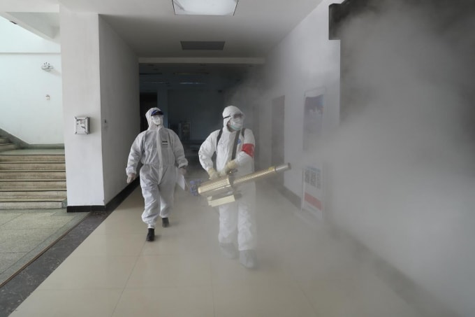 Người dân phun thuốc khử trùng ở Vũ Hán, Trung Quốc. Ảnh: Reuters