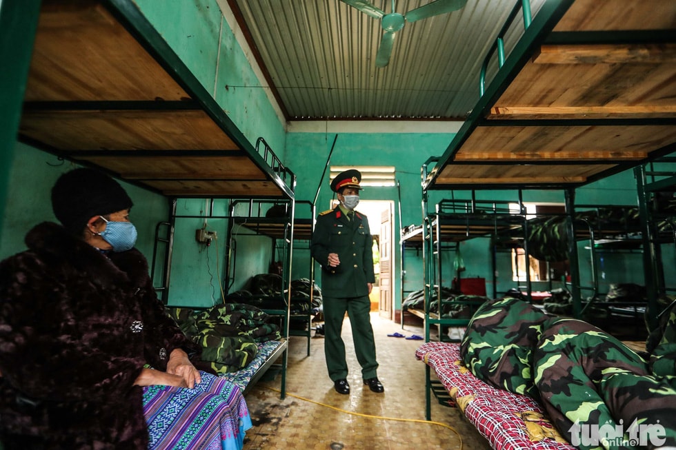 Đại tá Nguyễn Văn Đô, Phó Tham mưu Trưởng Bộ Chỉ huy quân sự tỉnh Lào Cai, hỏi thăm tình hình sức khỏe những người dân được cách ly trong đơn vị.