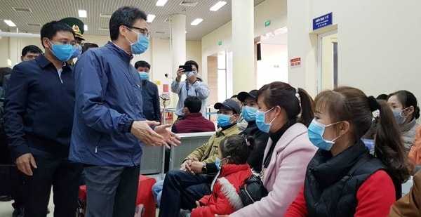 Phó Thủ tướng Vũ Đức Đam chia sẻ, động viên người dân chờ để đưa về khu vực cách ly 14 ngày ở TP.Móng Cái, Quảng Ninh, ngày 2/2/2020. Ảnh: TNMT