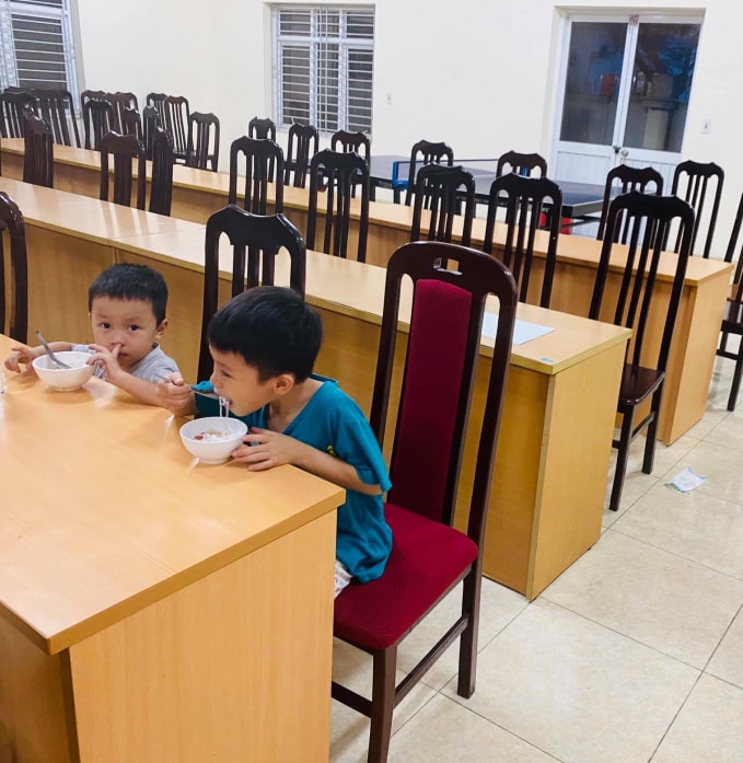Hai cháu bé ăn tối tại Đội CSGT số 4. Ảnh: Nguyễn Hùng