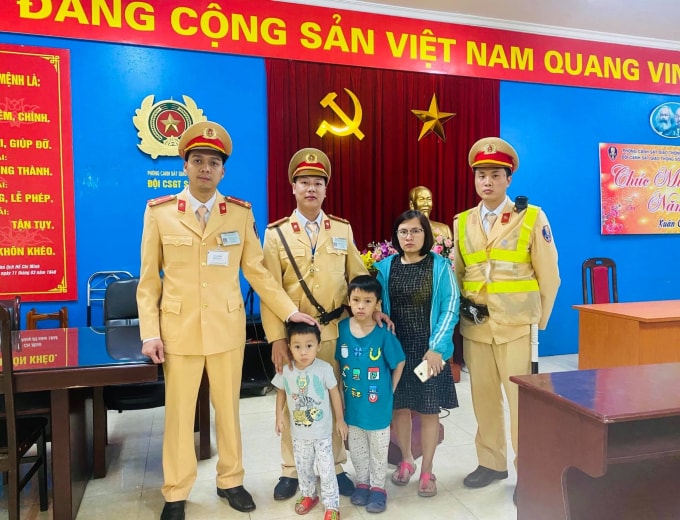Cán bộ đội CSGT số 4 bàn giao hai bé về với gia đình. Ảnh: Nguyễn Hùng