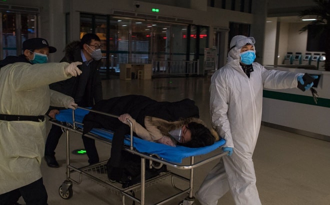 Các bác sĩ tại Vũ Hán đưa một phụ nữ mang thai nhiễm virus corona vào khu vực cách ly. Ảnh: Xinhua