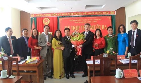 Tân chủ tịch UBND thành phố Trịnh Huy Triều (thứ 6 từ trái sang) nhận hoa chúc mừng từ lãnh đạo thành phố Thanh Hóa
