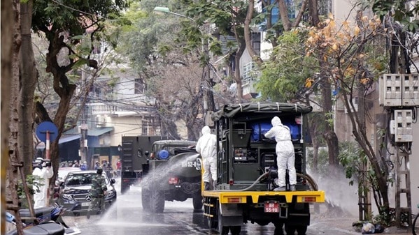 Lực lượng bộ đội hóa học phun hóa chất tẩy trùng khu vực phố Trúc Bạch, quận Ba Đình, nơi có nhà của bệnh nhân mắc COVID-19. Ảnh: TTXVN
