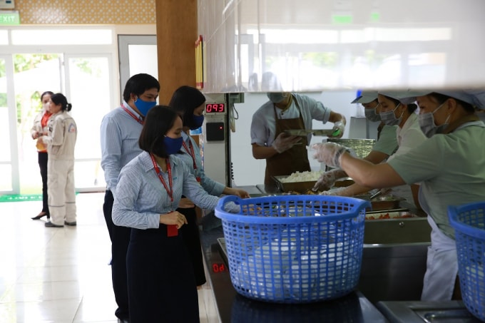 Khi lấy thức ăn trong bữa cơm trưa, CBCNV cũng đeo khẩu trang.