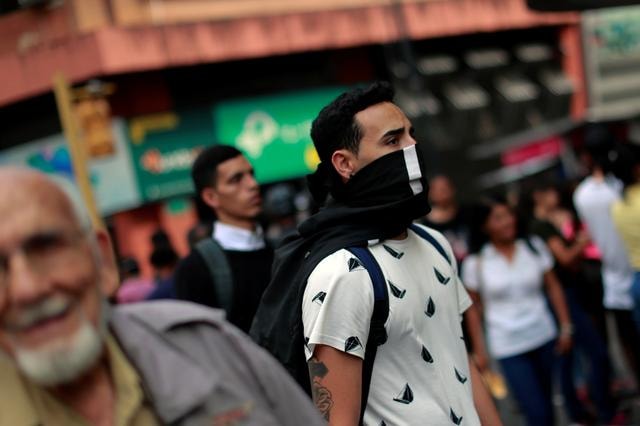 Một người đàn ông bịt mặt tại Caracas, Venezuela. Ảnh: Reuters